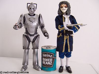 Toy cyberman and a toy clockwork droid next to a tin of baked beans Toy cyberman and a toy clockwork droid next to a tin of baked beans